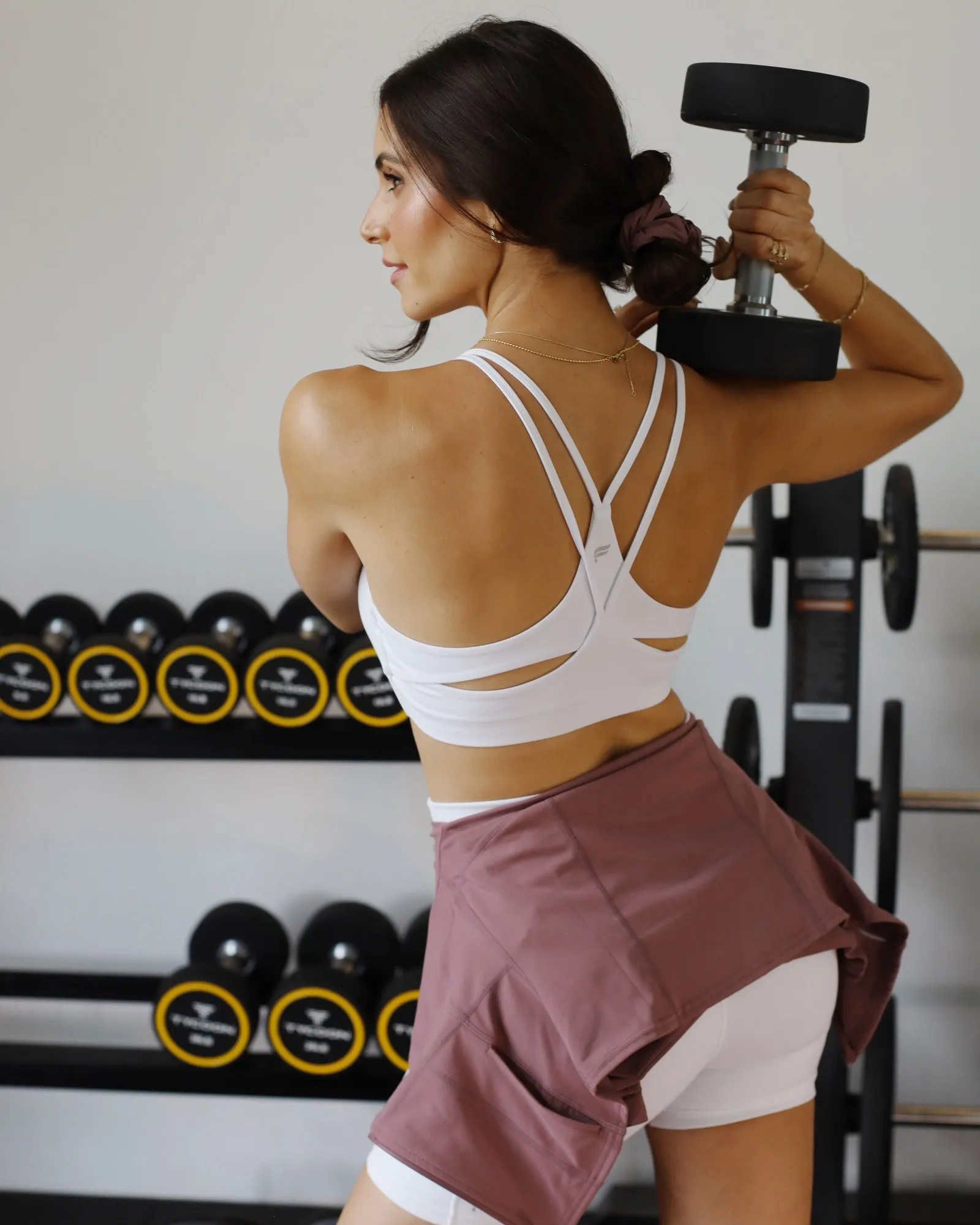 Merce entrenando con una mancuerna sobre el hombro